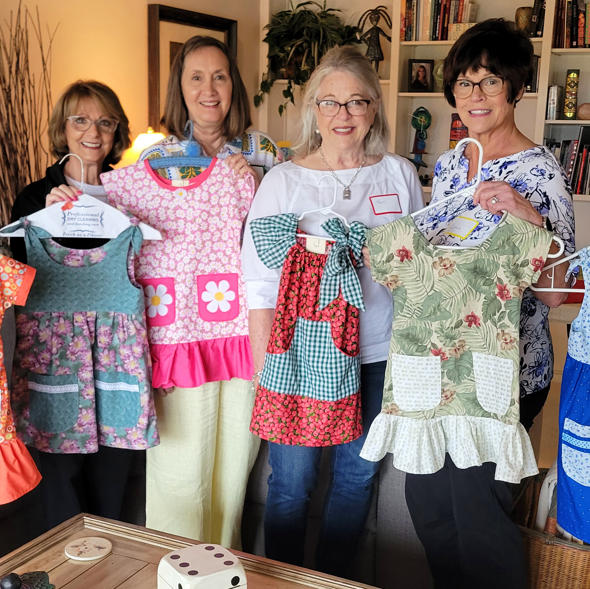 Sew Love volunteers displaying dresses